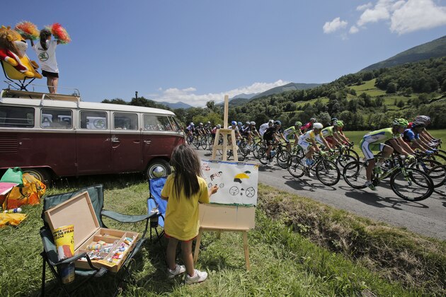 A child makes a painting of cyclists as the pack with Australia's Simon Gerrans passes during the sixteenth stage of the Tour de France cycling race over 237.5 kilometers (147.6 miles) with start in Carcassonne and finish in Bagneres-de-Luchon, France, Tuesday, July 22, 2014. (AP Photo/Christophe Ena)