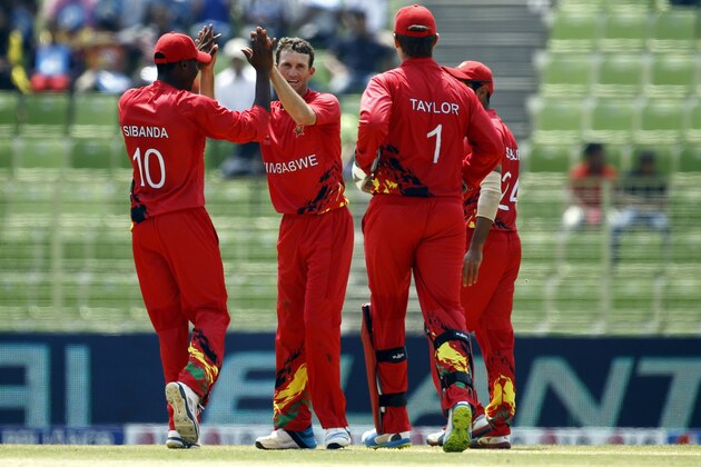 Zimbabwe's Sean Williams, second left, celebrates with his teammates the dismissal of United Arab Emirates' captain Khurram Khan during their ICC Twenty20 Cricket World Cup match in Sylhet, Bangladesh, Friday, March 21, 2014. (AP Photo/A.M. Ahad)