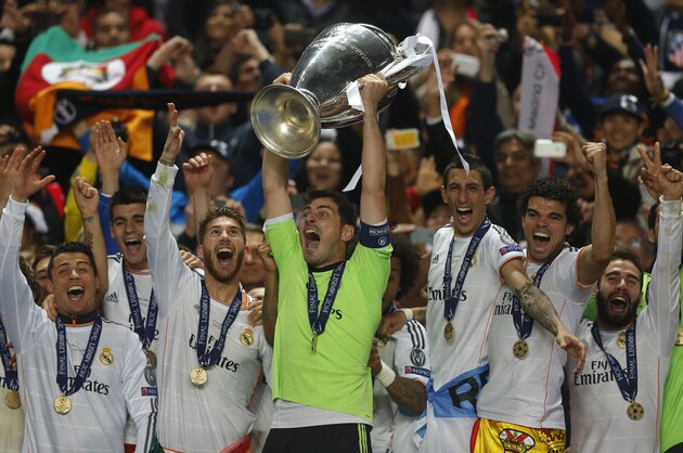 Real goalkeeper Iker Casillas, centre, lifts the Champion League trophy, as he and teammates, celebrate winning the Champion League title, against Atletico Madrid, in Lisbon, Portugal, Saturday, May 24, 2014. (AP Photo/Andres Kudacki)