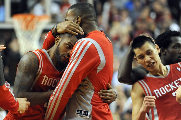 PORTLAND, OR - APRIL  25: Troy Daniels #30 of the Houston Rockets is mobbed by teammates after hitting what ended up being the game winning shot during overtime of Game Three of the Western Conference Quarterfinals during the 2014 NBA Playoffs against the Portland Trail Blazers at the Moda Center on April 25, 2014 in Portland, Oregon. The Rockets won the game 121-116. NOTE TO USER: User expressly acknowledges and agrees that, by downloading and or using this photograph, User is consenting to the terms and conditions of the Getty Images License Agreement.  (Photo by Steve Dykes/Getty Images)