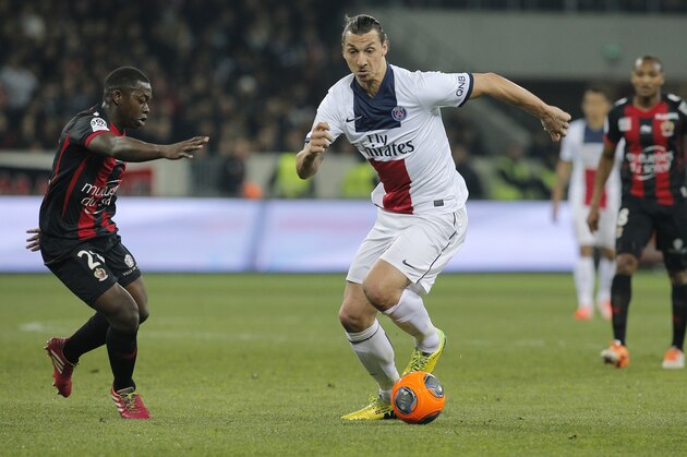 Paris Saint Germain's Zlatan Ibrahimovic of Sweden, right challenges for the ball with Nice's Nampalys Mendy of France during their French League One soccer match, in Nice stadium,southeastern France, Friday, March 28, 2014. (AP Photo/Lionel Cironneau)
