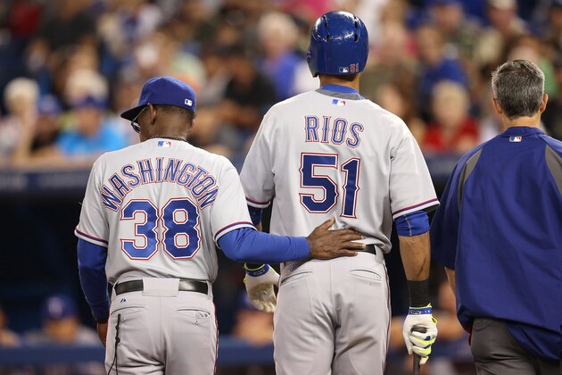 TORONTO, CANADA - JULY 19: Alex Rios #51 of the Texas Rangers exits the game after suffering a leg injury in the first inning as he is led away by manager Ron Washington #38 and trainer Kevin Harmon during MLB game action against the Toronto Blue Jays on July 19, 2014 at Rogers Centre in Toronto, Ontario, Canada. (Photo by Tom Szczerbowski/Getty Images)