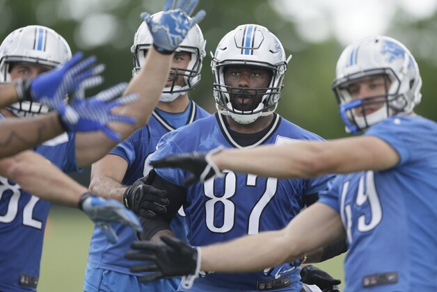 Detroit Lions tight end Brandon Pettigrew catches a ball through the distraction of teammates during an NFL football minicamp in Allen Park, Mich., Wednesday, June 11, 2014. (AP Photo/Carlos Osorio)