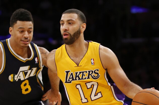 Los Angeles Lakers' Kendall Marshall, right, dribbles the ball past Utah Jazz's Diante Garrett, left, during the second half of an NBA basketball game in Los Angeles, Tuesday, Feb. 11, 2014. The Jazz won 96-79. (AP Photo/Danny Moloshok)
