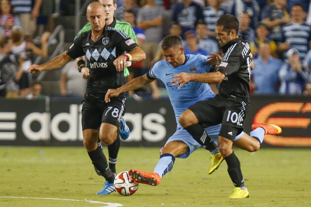 KANSAS CITY, KS - JULY 23:  Aleksandar Kolarov #11 of Manchester City fights off Aurelien Collin #78 and Benny Feilhaber #10 of Sporting KC late in the first half on July 23rd at Sporting Park in Kansas City, Kansas.  (Photo by Kyle Rivas/Getty Images)