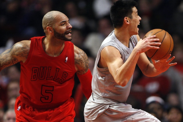 Dec 25, 2012; Chicago, IL, USA; Houston Rockets point guard Jeremy Lin (right) is fouled by Chicago Bulls power forward Carlos Boozer (5) during the third quarter at the United Center. Mandatory Credit: Jerry Lai-USA TODAY Sports