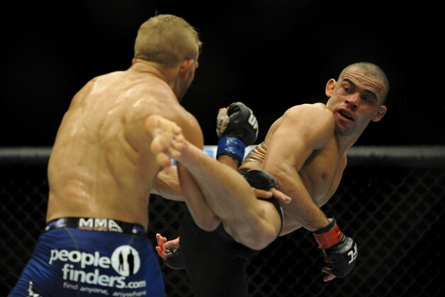 May 24, 2014; Las Vegas, NV, USA;  Renan Barao (red) throws a kick at TJ Dillashaw (blue) during their UFC 173 bantamweight championship bout at MGM Grand Garden Arena. Dillashaw won the bout by way of TKO. Mandatory Credit: Stephen R. Sylvanie-USA TODAY Sports
