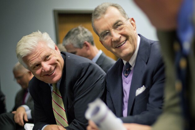 FILE- In this Nov. 26, 2013 file photo, Frank Wren, Atlanta Braves general manager,  left, and John Schuerholz, Braves president, talk with Mike Plant, right, executive vice president of business operations before the start of a Cobb County commission hearing on a proposed plan to build the team a new baseball stadium in the county in Marietta, Ga. The Atlanta Braves pulled perhaps the most surprising move of the year. No, they didn’t win a playoff series. They just announced after months of secret talks with Cobb County leaders plans to move to a suburban stadium and leave downtown where they’ve played since moving from Milwaukee in 1966. The impending Braves’ departure aside, Atlanta Mayor Kasim Reed managed to keep the NFL’s Atlanta Falcons happy. He agreed for the city to cover part of the construction costs for a new retractable-roof stadium to replace the Georgia Dome downtown. Both new stadiums are projected to open in 2017. (AP Photo/David Goldman, File)