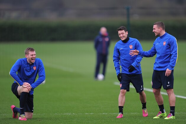 ST ALBANS, ENGLAND - FEBRUARY 18:  Per Mertesacker, Mesut Ozil and Lukas Podolski of Arsenal warm up during a training session at London Colney on February 18, 2014 in St Albans, England.  (Photo by Shaun Botterill/Getty Images)