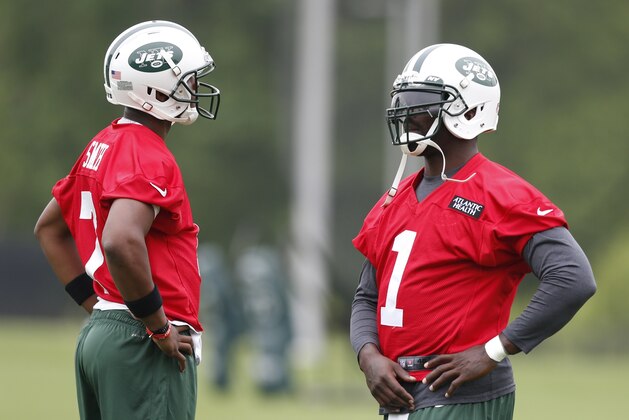 New York Jets quarterbacks Geno Smith, left, and Michael Vick stand next to each other during an NFL football organized team activity, Wednesday, May 28, 2014, in Florham Park, N.J. (AP Photo/Julio Cortez)