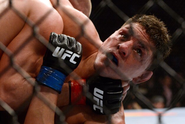 Mar 16, 2013; Montreal, Quebec, CAN;  Nick Diaz (blue) watches the clock in the final seconds of the fifth and final round during their Welterweight title bout against Georges St.Pierre at UFC 158 at the Bell Centre. Mandatory Credit: Eric Bolte-USA TODAY Sports