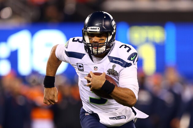EAST RUTHERFORD, NJ - FEBRUARY 02:  Quarterback Russell Wilson #3 of the Seattle Seahawks runs the ball against the Denver Broncos during Super Bowl XLVIII at MetLife Stadium on February 2, 2014 in East Rutherford, New Jersey.  (Photo by Elsa/Getty Images)