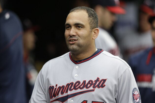 Minnesota Twins designated hitter Kendrys Morales smiles in the dugout against the Detroit Tigers in the first inning of a baseball game in Detroit, Friday, June 13, 2014.  (AP Photo/Paul Sancya)