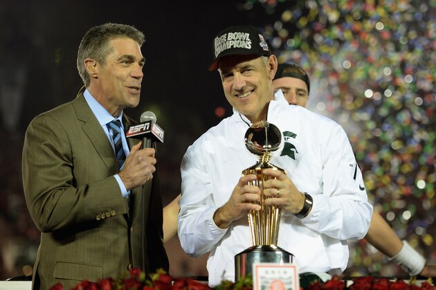 PASADENA, CA - JANUARY 01:  Michigan State Spartans head coach Mark Dantonio is presented the Rose Bowl Game trophy by ESPN's Chris Fowler after defeating the Stanford Cardinal 24-20 in the 100th Rose Bowl Game presented by Vizio at the Rose Bowl on January 1, 2014 in Pasadena, California.  (Photo by Harry How/Getty Images)