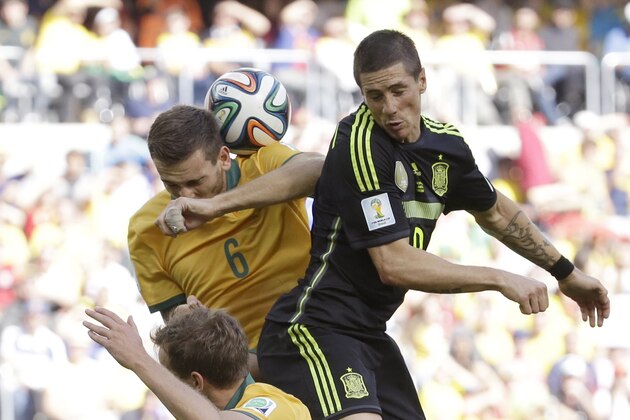 Spain's Fernando Torres goes for a header with Australia's Matthew Spiranovic during the group B World Cup soccer match between Australia and Spain at the Arena da Baixada in Curitiba, Brazil, Monday, June 23, 2014. (AP Photo/Fernando Vergara)