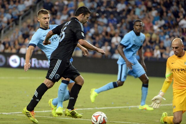 Jul 23, 2014; Kansas City, KS, USA; Sporting KC forward Claudio Bieler (16) moves towards goal against the Manchester City goal keeper Willy Caballero (13) in the second half at Sporting Park. Manchester City won 4-1. Mandatory Credit: John Rieger-USA TODAY Sports