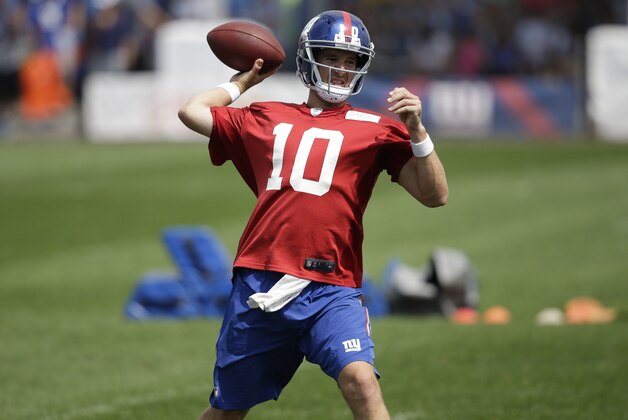 New York Giants quarterback Eli Manning looks to throw during a NFL football camp in East Rutherford, N.J., Tuesday, July 22, 2014. (AP Photo/Seth Wenig)