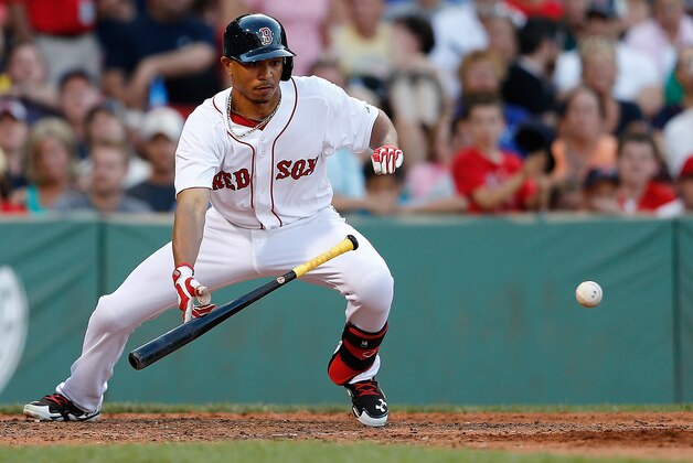 BOSTON, MA - JULY 10: Mookie Betts #50 of the Boston Red Sox bunts a man to second base in the tenth inning against the  Chicago White Sox iat Fenway Park on July 10, 2014 in Boston, Massachusetts. (Photo by Jim Rogash/Getty Images)