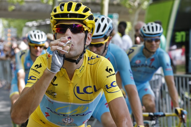 Team Astana with Italy's Vincenzo Nibali, wearing the overall leader's yellow jersey,  celebrates with a glass of champagne during the twenty-first and last stage of the Tour de France cycling race over 137.5 kilometers (85.4 miles) with start in Evry and finish in Paris, France, Sunday, July 27, 2014. (AP Photo/Jean-Paul Pelissier, Pool)