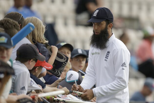 England's Moeen Ali signs autographs on the edge of the boundary as his side field during the second day of the third cricket test match of the series between England and India at The Ageas Bowl in Southampton, England, Monday, July 28, 2014. England cricketer Moeen Ali is unlikely to face punishment after being photographed wearing wristbands saying “Save Gaza” and “Free Palestine” while batting in the third test against India. The England and Wales Cricket Board says “we don't believe he has committed an offence.” (AP Photo/Matt Dunham)