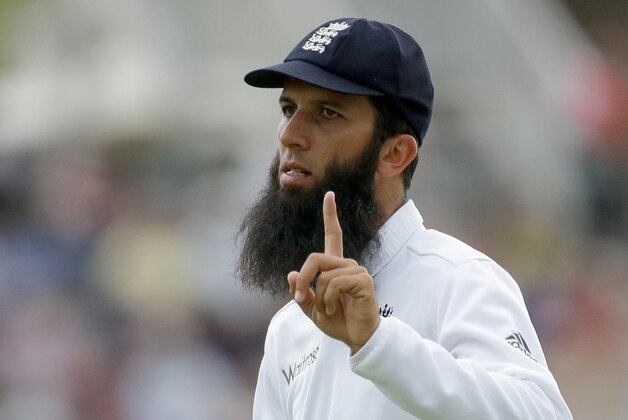 England's Moeen Ali gestures to fans to wait as he fields before signing autographs for them on the edge of the boundary during the second day of the third cricket test match of the series between England and India at The Ageas Bowl in Southampton, England, Monday, July 28, 2014. (AP Photo/Matt Dunham)