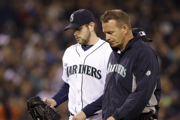 Seattle Mariners starting pitcher James Paxton, left, is accompanied by a trainer as he leaves the baseball game against the Los Angeles Angels in the sixth inning Tuesday, April 8, 2014, in Seattle. Paxton strained a muscled in his left side, the team said. (AP Photo/Elaine Thompson) Seattle Mariners starting pitcher James Paxton, left, is accompanied by a trainer as he leaves the baseball game against the Los Angeles Angels in the sixth inning Tuesday, April 8, 2014, in Seattle. Paxton strained a muscled in his left side, the team said. (AP Photo/Elaine Thompson)