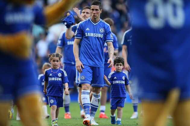 Chelsea's Fernando Torres walks with his two children on the pitch following the English Premier League soccer match between Chelsea and Norwich City at Stamford Bridge stadium in London Sunday, May 4, 2014. The players traditionally walk round the pitch with their family after the last home game of the season. (AP Photo/Alastair Grant)