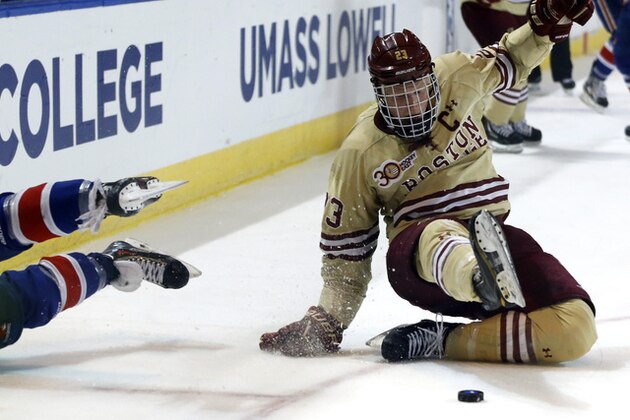 Boston College's Patrick Brown (23) tries to regain his footing after crashing with UMass Lowell's Jake Suter, left, while vying for the puck in the first period of the NCAA Northeast Regional hockey final in Worcester, Mass., Sunday, March 30, 2014. (AP Photo/Elise Amendola)