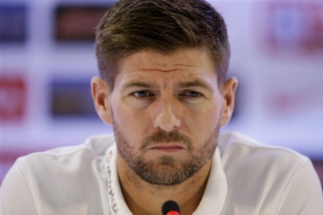 FILE - In this Sunday, June 22, 2014 file photo, England national soccer team captain Steven Gerrard listens as head coach Roy Hodgson speaks during a press conference after a squad training session that was closed to the media for the 2014 soccer World Cup at the Urca military base in Rio de Janeiro, Brazil. England captain Steven Gerrard announced his retirement from international football on Monday, July 21, 2014. The 34-year-old Liverpool midfielder made 114 appearances for England over 14 years. (AP Photo/Matt Dunham, File)