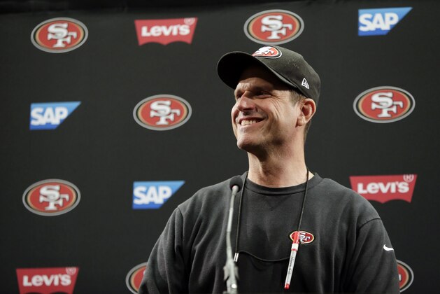 San Francisco 49ers head coach Jim Harbaugh smiles as he answers questions from the media during an NFL football training camp on Thursday, July 24, 2014, in Santa Clara, Calif. (AP Photo)