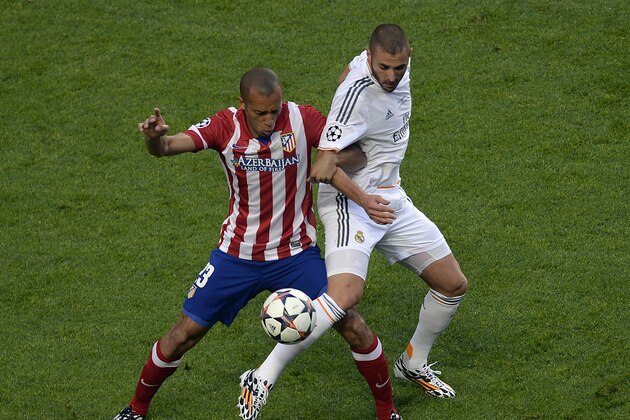 Real's Karim Benzema, right, and Atletico's Miranda during the Champions League final soccer match between Atletico Madrid and Real Madrid in Lisbon, Portugal, Saturday, May 24, 2014. (AP Photo/Paulo Duarte)