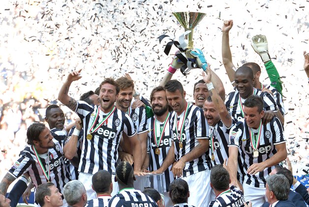 Juventus' players and staff celebrate at the end of a Serie A soccer match between Juventus and Cagliari at the Juventus  Stadium in Turin, Italy, Sunday, May 18, 2014. Juventus celebrated its third straight Serie A title with a 3-0 home victory over Cagliari to set a new European record of 102 points. Antonio Conte's side had already broken the Serie A points record but ensured it moved into triple figures by also becoming the first Italian side to maintain a 100% home record.(AP Photo/Massimo Pinca)