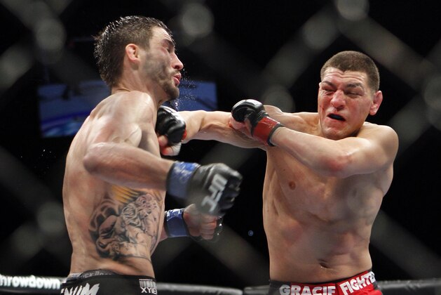 Nick Diaz , right, trades punches with Carlos Condit during their UFC interim welterweight mixed martial arts title match, Saturday, Feb. 4, 2012 at The Mandalay Bay Resort & Casino in Las Vegas. Condit won by unanimous decision. (AP Photo/Eric Jamison)