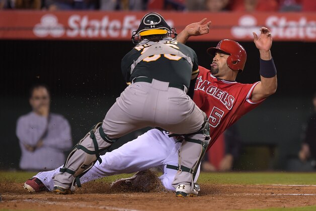 Los Angeles Angels' Albert Pujols, right, is tagged out by Oakland Athletics catcher Derek Norris while trying to score on a single by Josh Hamilton during the sixth inning of a baseball game, Tuesday, June 10, 2014, in Anaheim, Calif. (AP Photo/Mark J. Terrill)