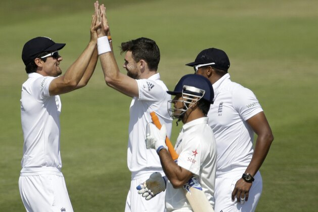 England's James Anderson, center, celebrates with captain Alastair Cook, left, beside Chris Jordan after taking the wicket of India's captain and wicketkeeper Mahendra Singh Dhoni, second right, during the fourth day of the third cricket test match of the series between England and India at The Ageas Bowl in Southampton, England, Wednesday, July 30, 2014.  (AP Photo/Matt Dunham)