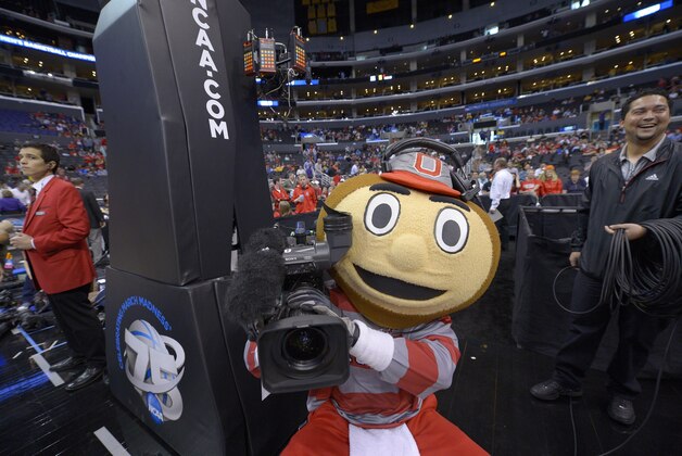 Ohio State's mascot, Brutus Buckeye, grabs a television camera before the start of a West Regional final against Wichita State in the NCAA college basketball tournament, Saturday, March 30, 2013, in Los Angeles. (AP Photo/Mark J. Terrill)
