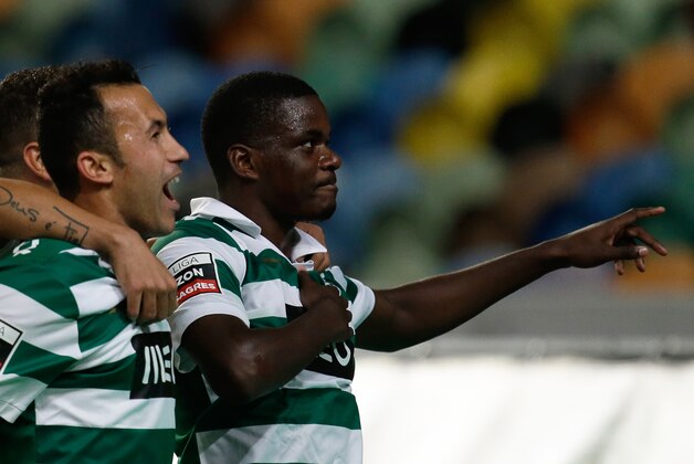 Sporting's William Carvalho, right, celebrates after scoring the opening goal against Pacos de Ferreira during their Portuguese league soccer match Sunday, Dec. 1, 2013, at Sporting's Alvalade stadium in Lisbon. (AP Photo/Armando Franca)