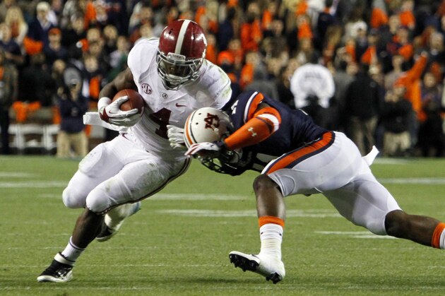 Alabama running back T.J. Yeldon (4) tries to get around Auburn cornerback Chris Davis (11) for a first down during the second half of an NCAA college football game on Saturday, Nov. 30, 2013, in Auburn, Ala. (AP Photo/Butch Dill)
