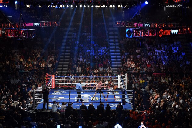 LAS VEGAS, NV - JULY 12:  (L-R) Referee Robert Byrd looks on as Canelo Alvarez hits Erislandy Lara in the third round of their junior middleweight bout at the MGM Grand Garden Arena on July 12, 2014 in Las Vegas, Nevada.  (Photo by Ethan Miller/Getty Images)