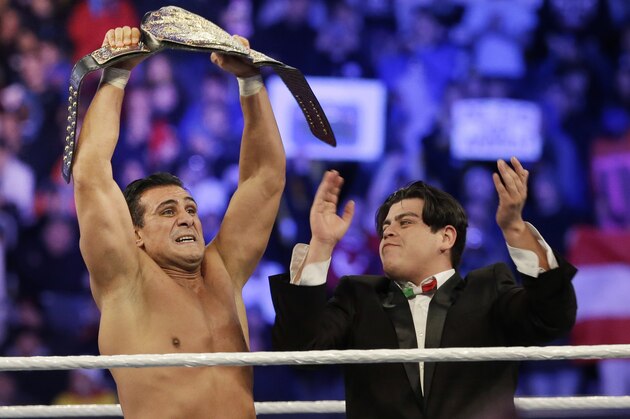 Jose Alberto Rodríguez, of Mexico, known as Alberto Del Rio stands with his manager, Ricardo Rodriguez, right, as he holds up a championship belt after defeating Jacob