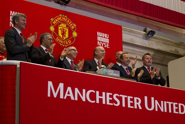 Executives from Manchester United, including Avram Glazer, fourth from left, and Joel Glazer, third from left, applaud after ringing the opening bell at the New York Stock Exchange on Friday, Aug. 10, 2012 in New York. Shares of soccer club Manchester United made their public debut Friday, edging up slightly as shareholders' enthusiasm for the celebrated team was offset by worry about its debt load and financial performance. (AP Photo/Jin Lee)