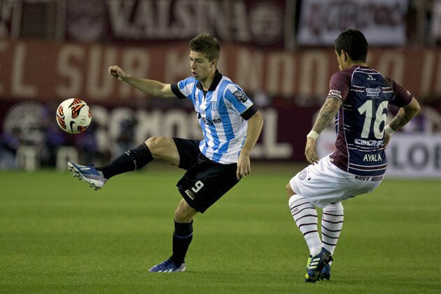 Racing Club's Luciano Vietto, left, vies for the ball with Victor Ayala of Lanus at a Copa Sudamericana soccer match in Buenos Aires, Argentina, Wednesday, Aug. 28, 2013. (AP Photo/Eduardo Di Baia)