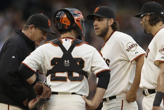 San Francisco Giants' Madison Bumgarner, third from left, speaks with pitching coach Dave Righetti, left, and catcher Buster Posey (28) in the first inning of a baseball against the Pittsburgh Pirates Monday, July 28, 2014, in San Francisco. (AP Photo/Ben Margot)