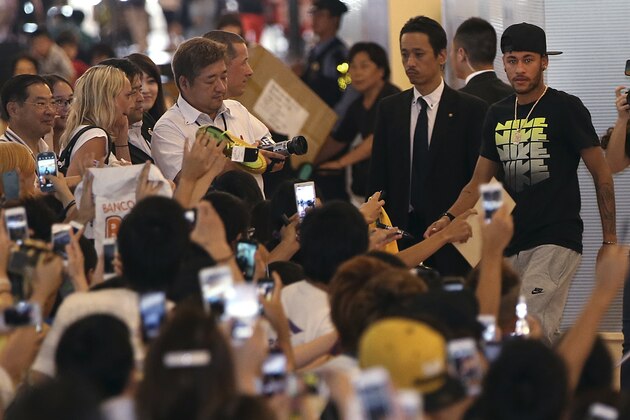 Brazilian soccer player Neymar, right, approaches to his fans upon arrival at Haneda airport in Tokyo, Thursday, July 31, 2014. Neymar is in Tokyo for several promotional events. (AP Photo/Eugene Hoshiko)