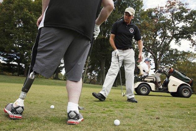 In this photo taken on Friday, Oct. 9, 2009, Army Staff Sgt. Richard Hoskins, of Bremton, Wash., a patient at Walter Reed Army Medical Center from Diamond Head, Miss., mimics the movement of Dave Nichols, right, of Stoneridge, N.Y., while golfing at Woodmont Country Club in Rockville, Md., as part of the Wounded Warrior Project. Nichols is a double amputee below the knee from injuries sustained in Vietnam. (AP Photo/Jacquelyn Martin)