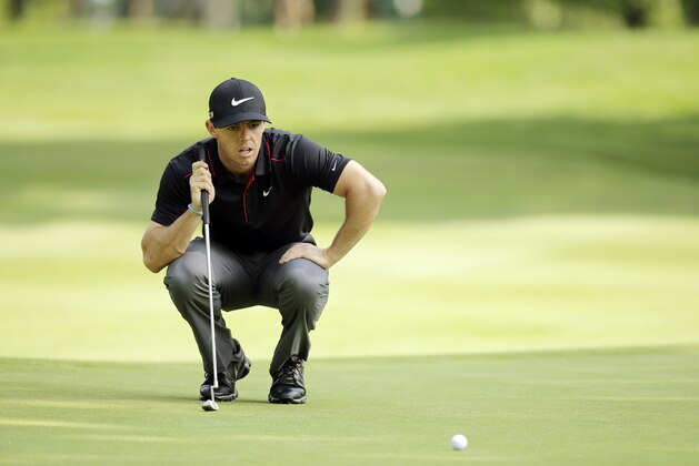 Rory McIlroy looks over a putt on the 11th green during the first round of the Bridgestone Invitational golf tournament Thursday, July 31, 2014, at Firestone Country Club in Akron, Ohio. (AP Photo/Mark Duncan)