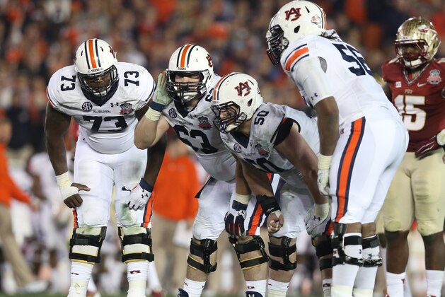 Jan 6, 2014; Pasadena, CA, USA; Auburn Tigers guard Alex Kozan (63) tries to hear the play call while in the huddle with tackle Greg Robinson (73) center Reese Dismukes (50) and tackle Avery Young (56) against the Florida State Seminoles during the second half of the 2014 BCS National Championship game at the Rose Bowl. Mandatory Credit: Matthew Emmons-USA TODAY Sports