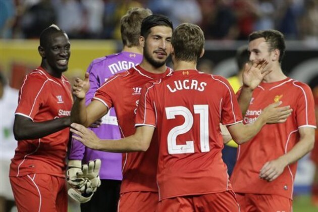 Liverpool midfielder Lucas Leiva (21) is congratulated by teammates after kicking the winning goal in a penalty kick shootout against Manchester City to win after being tied 2-2 in a Guinness International Champions Cup soccer tournament match, Wednesday, July 30, 2014, at Yankee Stadium in New York. (AP Photo/Julie Jacobson)