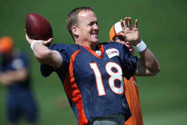 Denver Broncos quarterback Peyton Manning warms up during the morning session at the team's NFL training camp at Broncos headquarters in Englewood, Colo., on Friday, Aug. 1, 2014. (AP Photo/David Zalubowski)