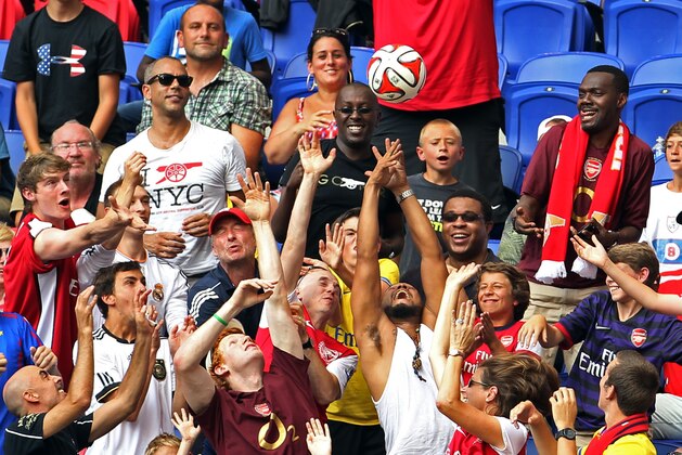 Fans try to catch a ball that was kicked into the stands during the first half of an international friendly soccer game between the New York Red Bulls and Arsenal, Saturday, June 26, 2014, in Harrison, N.J. (AP Photo/Adam Hunger)